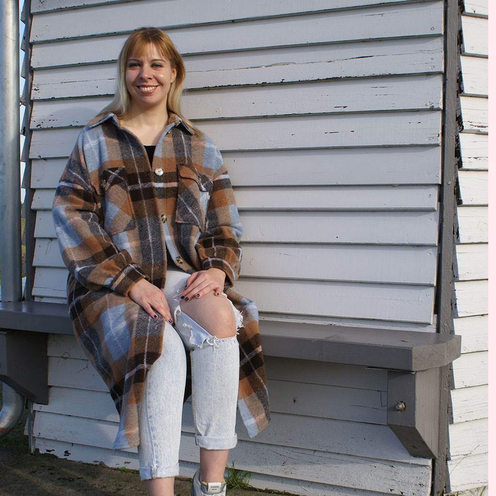 Laura Meier Dream Career Coach sitting on bench on the North Sea